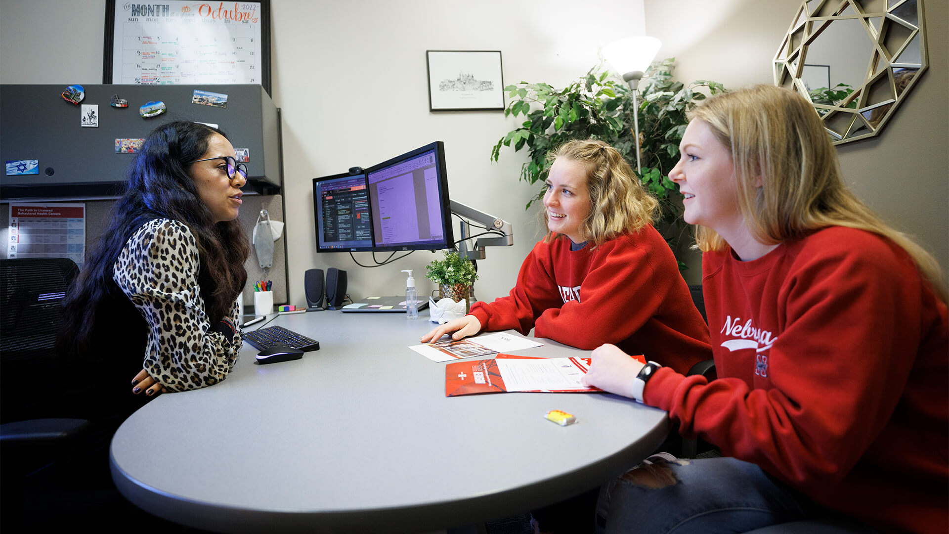 Students talking with advisor in office