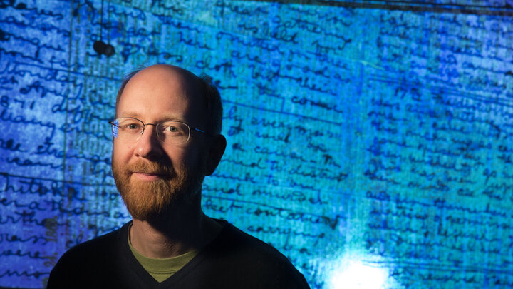 drian S. Wisnicki, assistant professor of English, stands in front of a projected image of Dr. David Livingstone's 1871 diaries made readable using spectral imaging technology.